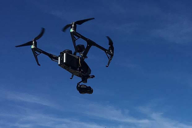 Un drone noir volant dans les airs.